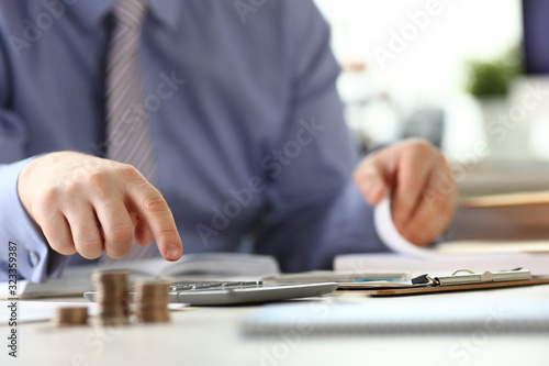 Man with Ring Calculate Revenue Tax Report Concept. Businessman Accounting Financial Business Data Using Calculator, Stationery at Workplace. Office Worker do Bureaucracy Paperwork © H_Ko