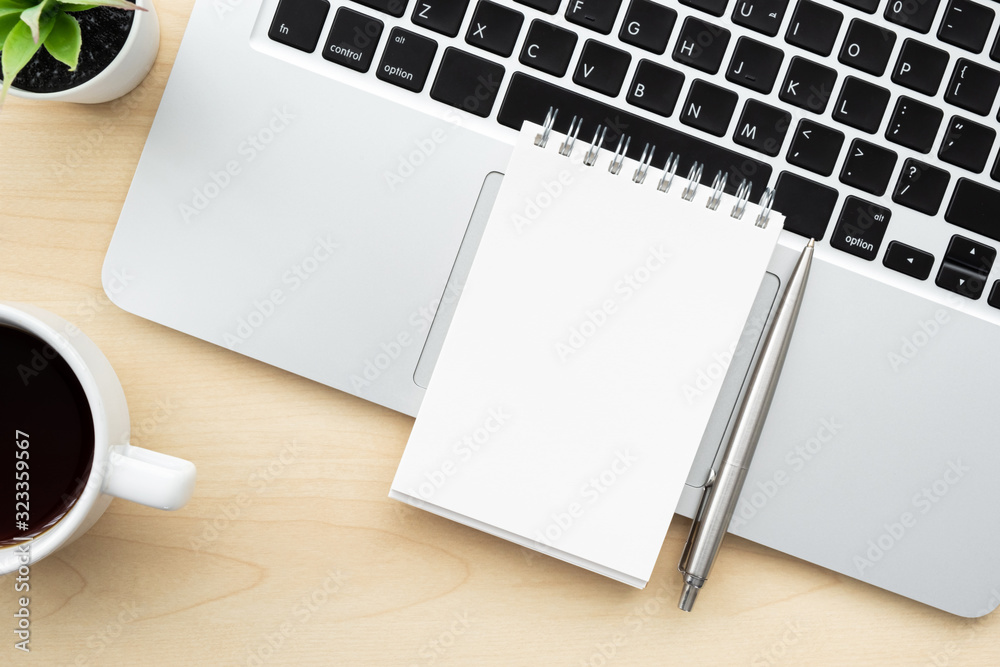 Foto de Blank notebook is on top of laptop computer over wood office desk  table with pen and cup of coffee. Top view, flat lay. do Stock | Adobe Stock