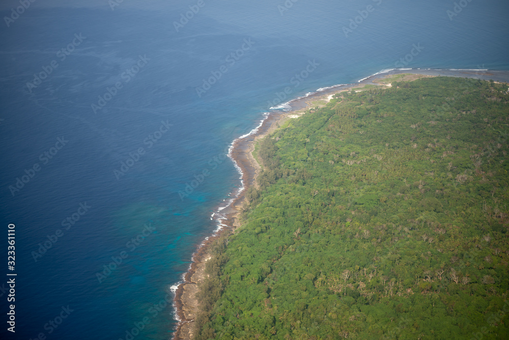 Aerial photo of the coast of Vanuatu of green fields and blue ocean
