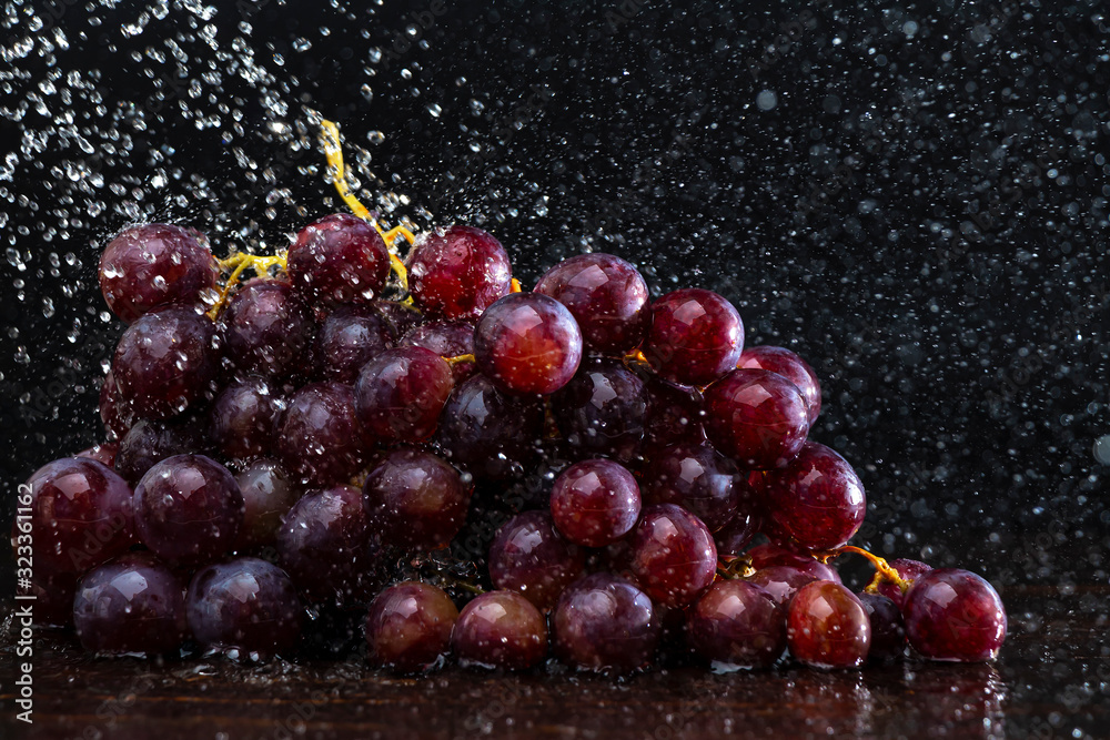 Grapes in spray of water close-up on a black background Grapes in spray of water close-up on a black background
