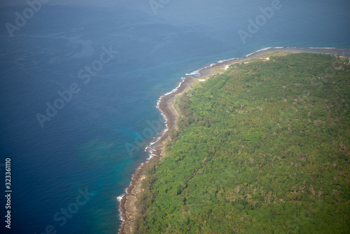 Aerial photo of the coast of Vanuatu of green fields and blue ocean