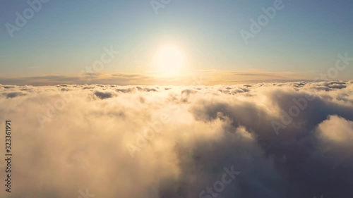 Aerial view running clouds in the sky in motion. Aerial view white clouds in blue sky during sunrise or sunset. Aerial top view cloudscape. Texture of clouds. Panoramic view. Fast playback	