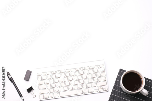 Flat lay top view modern office desk business workspace with computer keyboard pen and coffee cup on white background