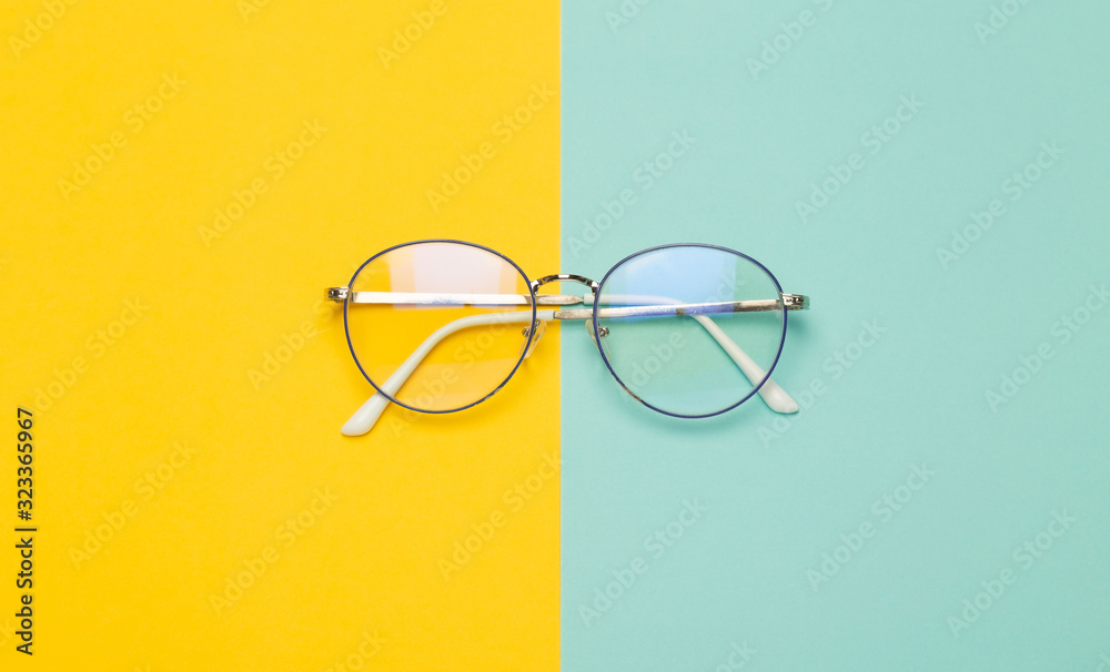 Eye glasses isolated on yellow and blue background. - obrazy, fototapety, plakaty 