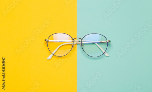 Eye glasses isolated on yellow and blue background. photo