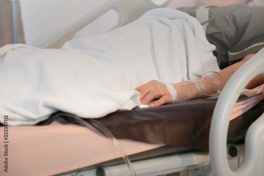 Focus on the hand of a patient in hospital room