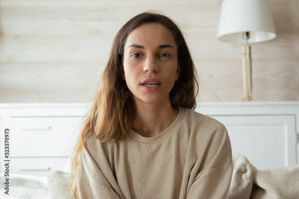 Millennial woman look at camera talk on video call Millennial woman look at camera talk on video call