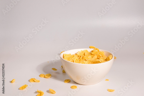 Corn flakes falling to the white bowl. Motion.
