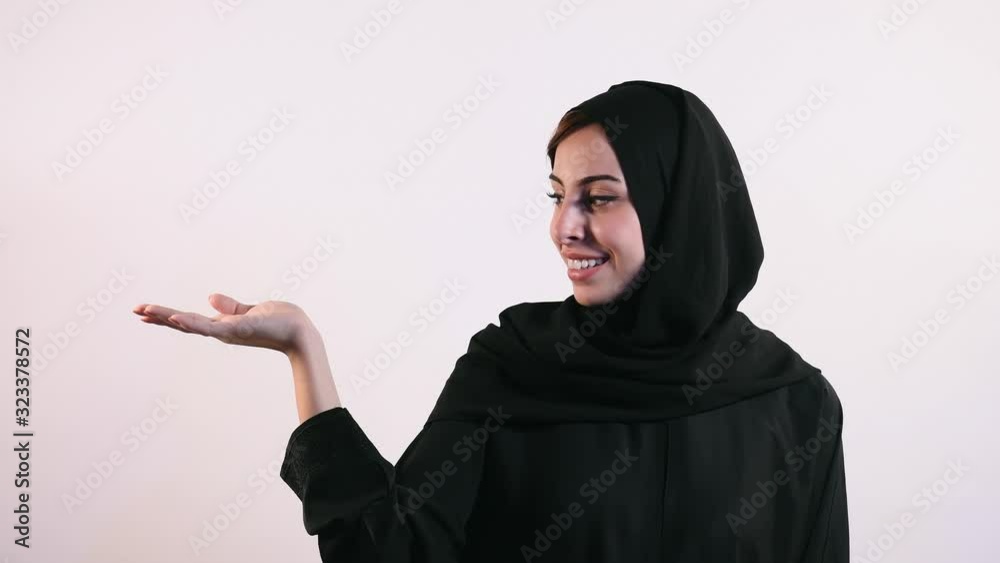 Happy Arabian female model showing arm advertising area isolated on white background, 4K Resolution Happy Arabian female model showing arm advertising area isolated on white background, 4K Resolution