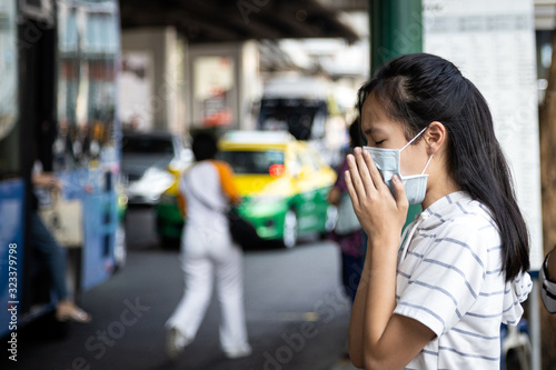 Asian child girl suffer from cough,sneeze with protection mask,sick woman wearing medical mask to prevent air pollution in the city,girl with face mask,concept of pollution,dust allergies,bad health