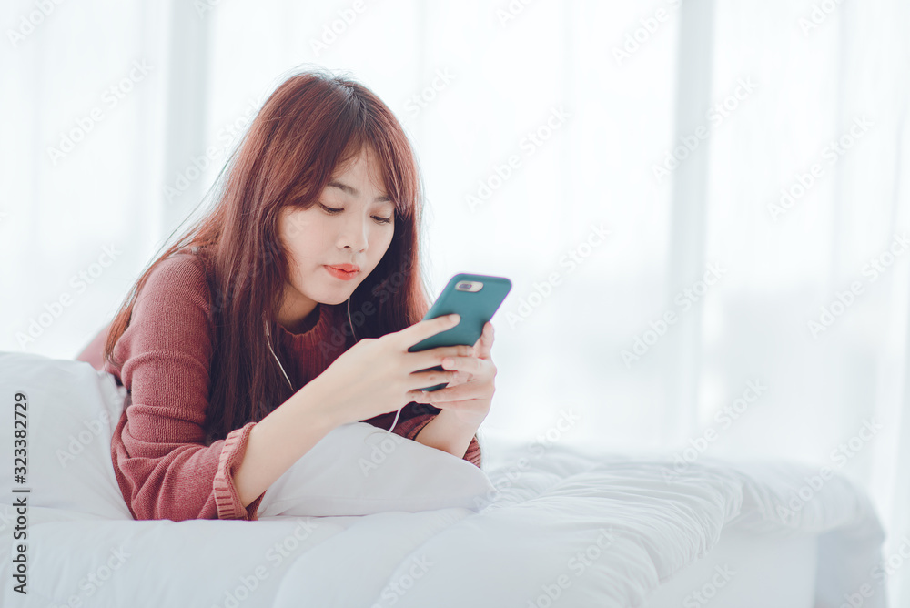 A woman playing on the phone in the bed in the house A woman playing on the phone in the bed in the house