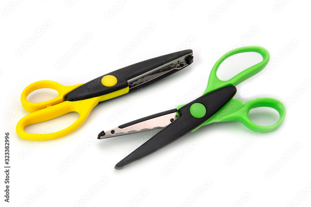 Two green and yellow zigzag craft scissors isolated on white background Two green and yellow zigzag craft scissors isolated on white background