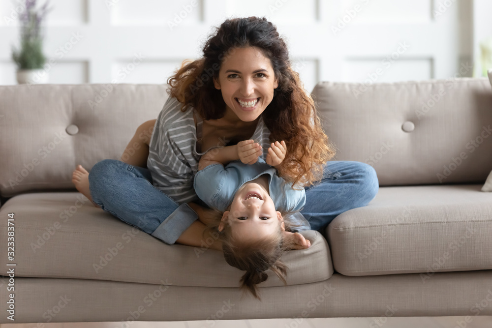 Happy attractive young mom tickling little preschool daughter. Happy attractive young mom tickling little preschool daughter.