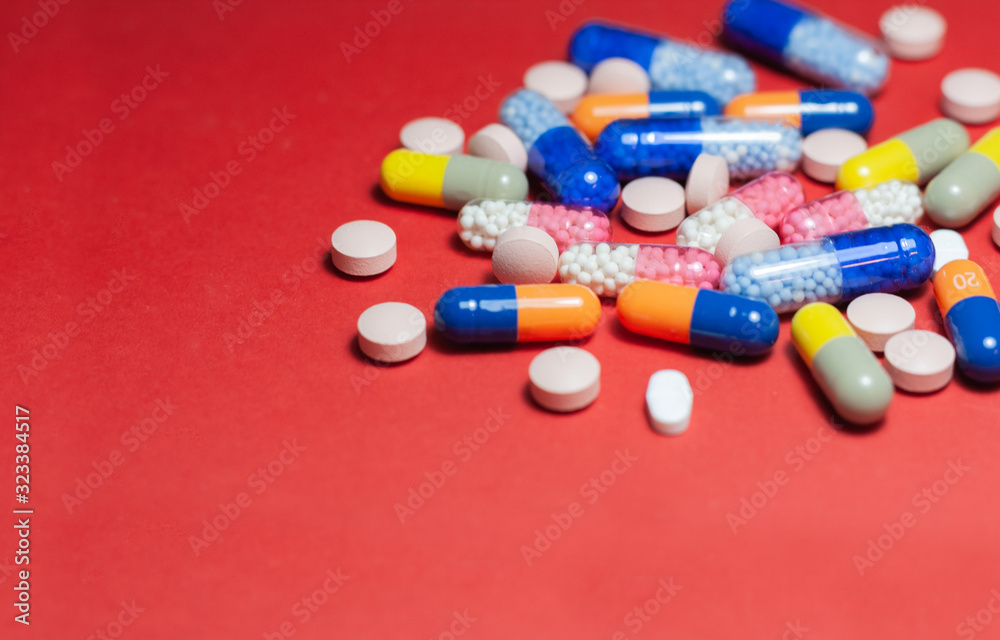 Heap of pills, tablets, capsules on red background. Drug prescription for treatment medication health care concept wth copy space. Heap of pills, tablets, capsules on red background. Drug prescription for treatment medication health care concept wth copy space.