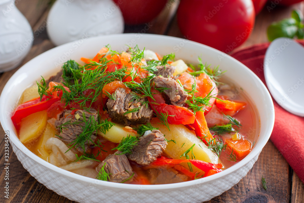 Khashlama with beef and vegetables on a wooden table, selective focus Khashlama with beef and vegetables on a wooden table, selective focus