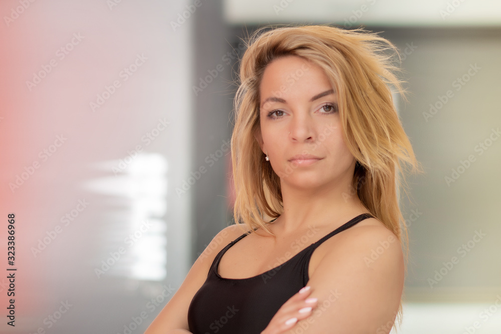Fototapeta premium Beautiful athletic sexy girl with long blonde hair and slim body in a fitness club.