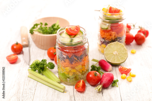 colorful vegetable salad in jar with radish, cucumber, tomato and celery
