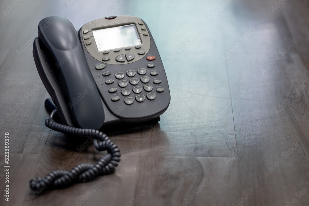 Close Up analog phone is placed on a wooden floor in the office. Close Up analog phone is placed on a wooden floor in the office.