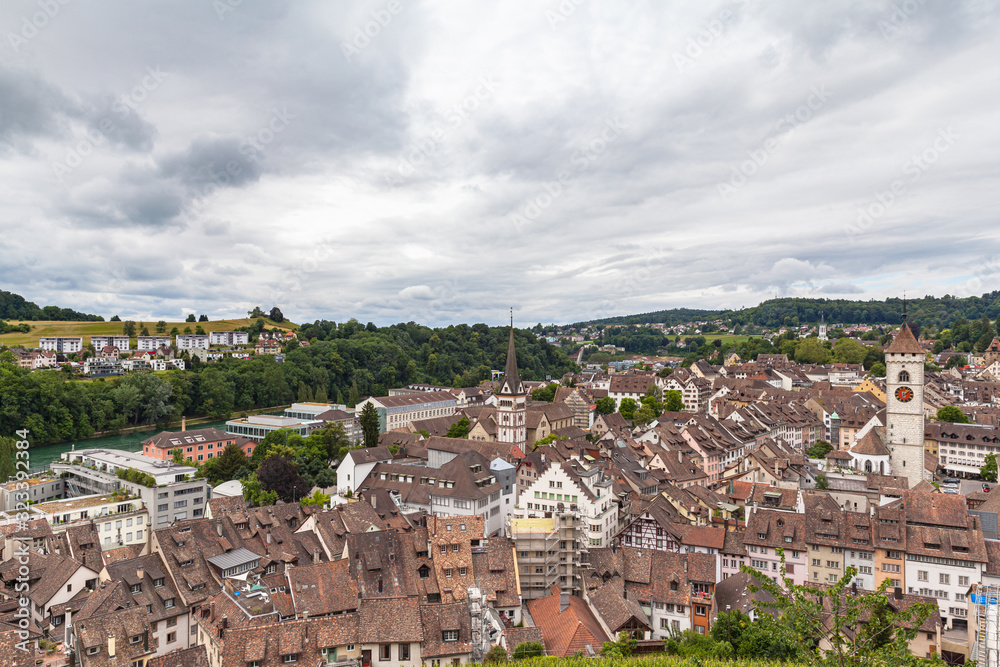 Aerial panorama view of old town cityscape of Schaffhausen and the Rhine river from the Munot fortification in summer on a cloudy day with beautiful cloudscape and mountains in background, Switzerland