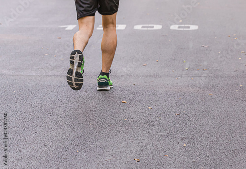 A man and a  woman are jogging in the evening on the public park