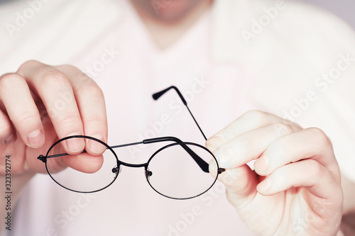 The concept of poor vision. Hold a contact lens and glasses in hand. A poster for advertising glasses and lenses.