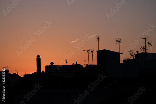 Silhouette of houses and antennas in the neighbourhood Gracia in Barcelona Spain at Sunrise