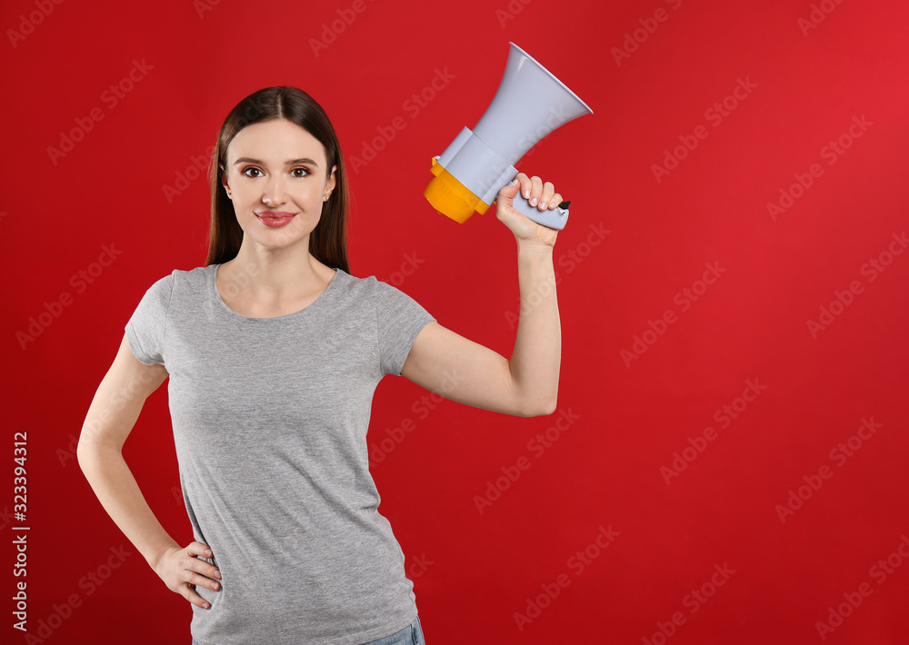 Young woman with megaphone on red background. Space for text Young woman with megaphone on red background. Space for text
