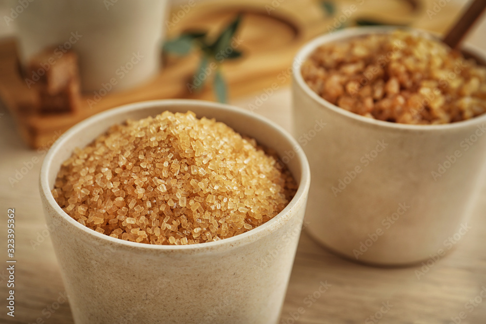 Brown sugar in bowl on wooden table, closeup Brown sugar in bowl on wooden table, closeup
