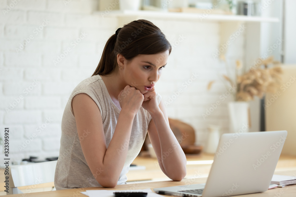 Pensive girl look at laptop screen thinking of problem solution Pensive girl look at laptop screen thinking of problem solution