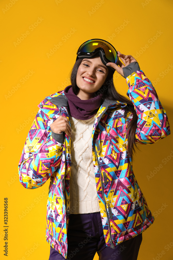 Woman wearing stylish winter sport clothes on yellow background Woman wearing stylish winter sport clothes on yellow background