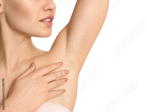Young woman showing armpit with smooth clean skin on white background, closeup