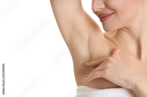 Young beautiful woman showing armpit with smooth clean skin on white background, closeup photo