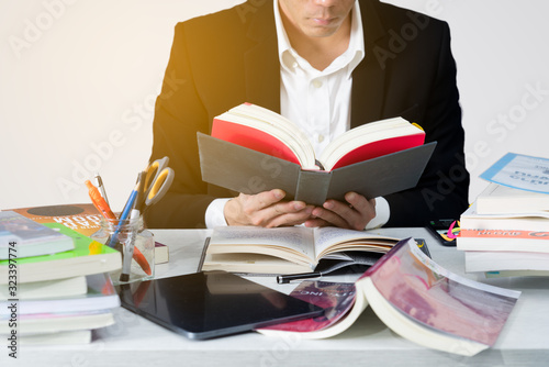 A business man reading book and using digital devices to make plan and analy photo