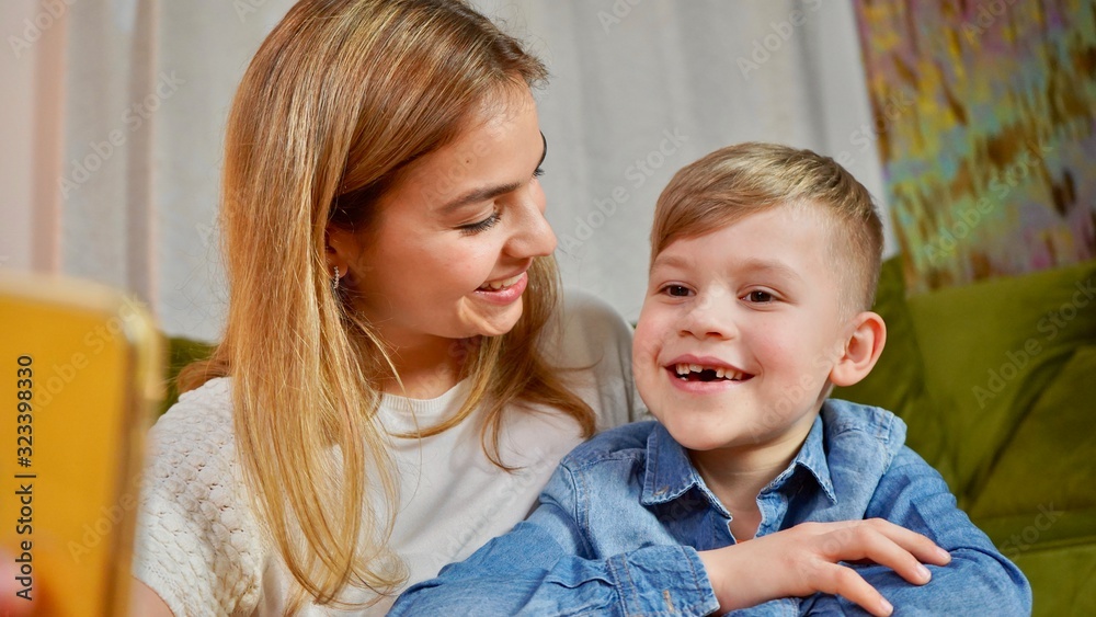 Beautiful mom and son making selfie at home. Happy family having a facetime video call. Unity, connection, technology concept Beautiful mom and son making selfie at home. Happy family having a facetime video call. Unity, connection, technology concept