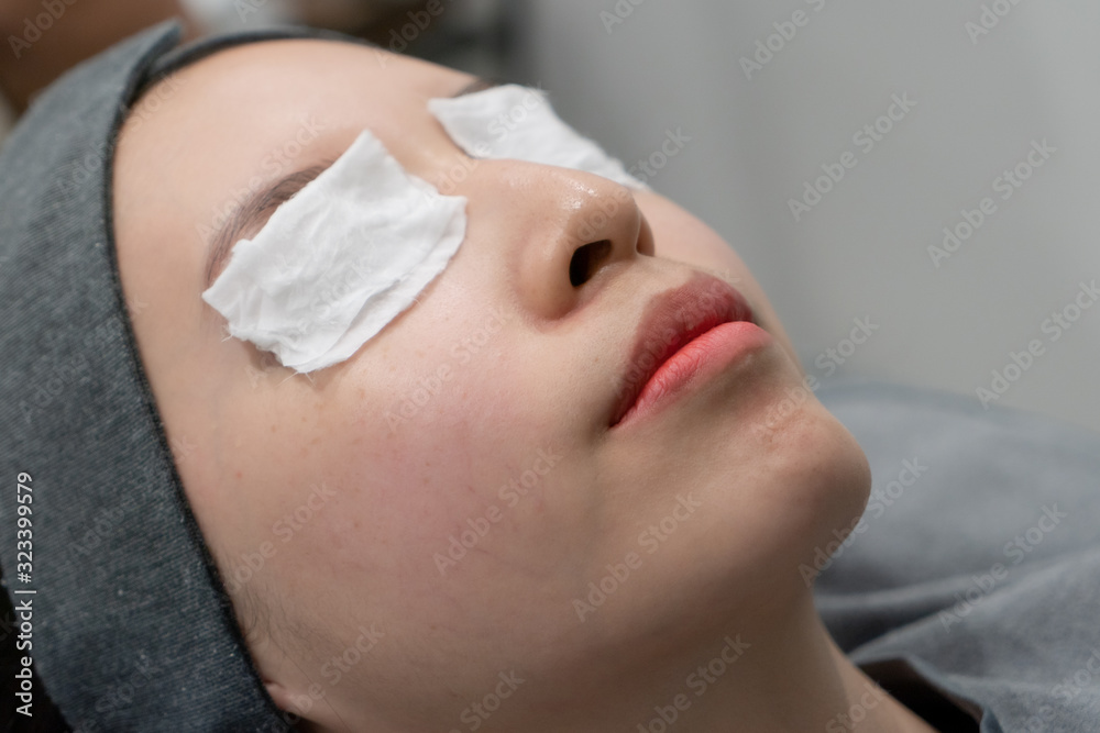 Cosmetologist puts a bandage on the face. preparation face skin before applying a rejuvenating mask in a beauty salon. Cosmetologist puts a bandage on the face. preparation face skin before applying a rejuvenating mask in a beauty salon.