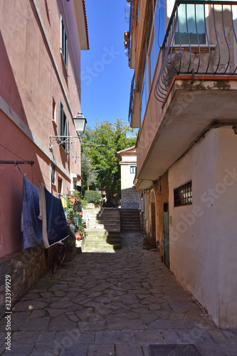 Acciaroli, Italy, 02/15/2020. A narrow street between the old houses of a village in southern Italy photo