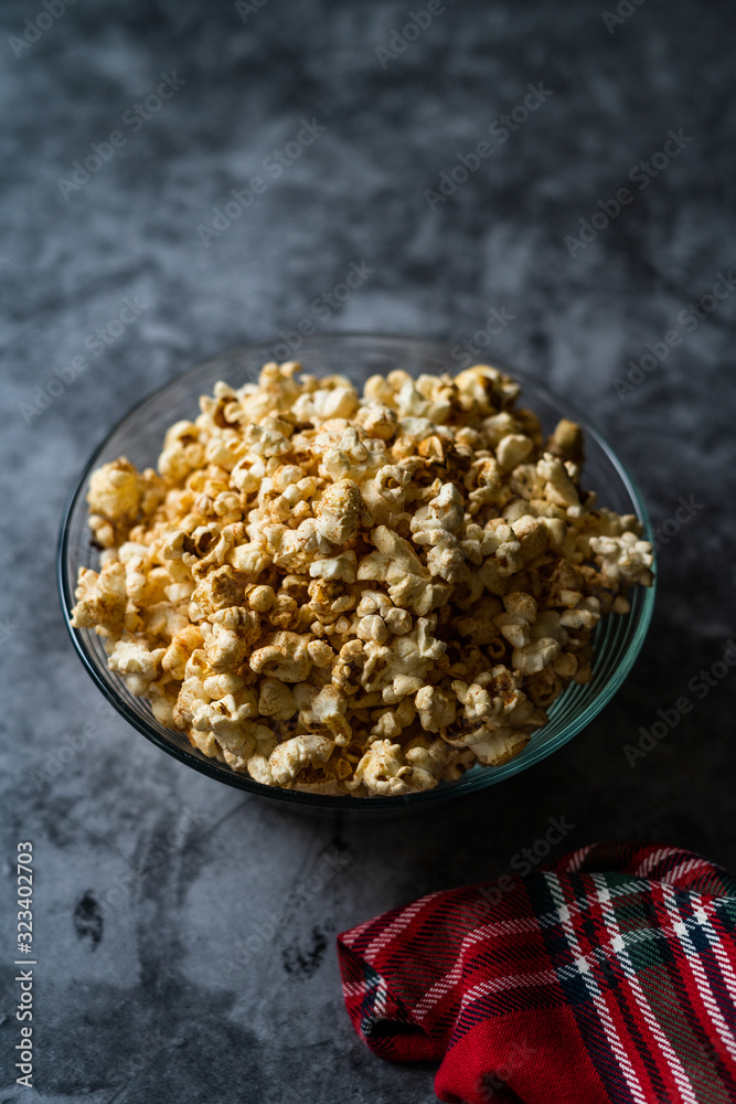 Caramel Popcorn in Glass Bowl on Grey Surface. Caramel Popcorn in Glass Bowl on Grey Surface.