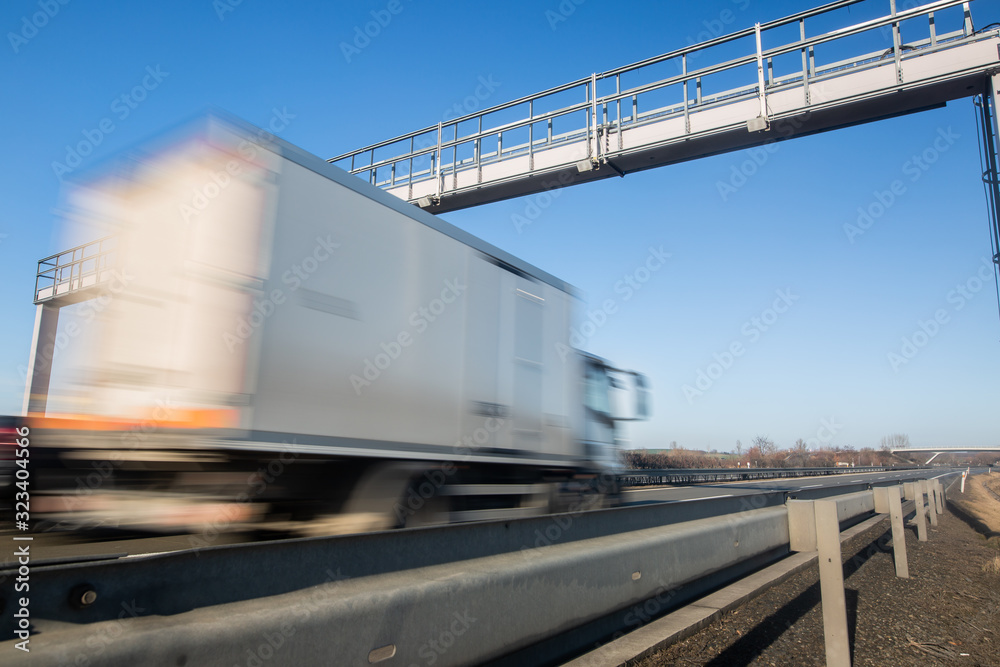 Truck passing through a toll gate on a highway, highway charges, motion blurred image