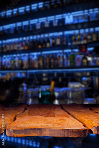 Wallpaper Mural Wooden board on a background of bottles with alcohol. Old bar counter as layout for design. Workpiece for design. Empty place to advertise products. Blurred interior of the bar in the background. Torontodigital.ca