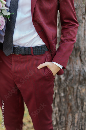 Young businessman man holds hand in trouser pocket.