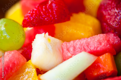 Close-up of tropical fruit salad featuring brightly colored watermelon, pineapple, grape, cantaloupe, strawberry, and orange slices