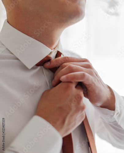 A young man puts on a tie. Businessman.
