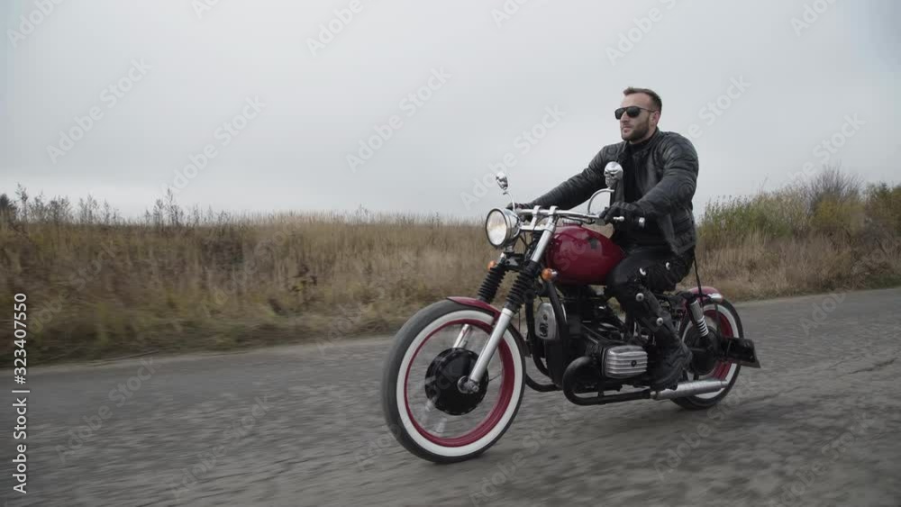 Confident biker driving with high speed on roadway Confident biker driving with high speed on roadway