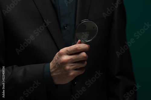 Man holding a magnifier and a business card