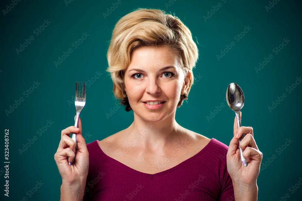 A portrait of hungry woman holding spoon and fork. People,lifest A portrait of hungry woman holding spoon and fork. People,lifest