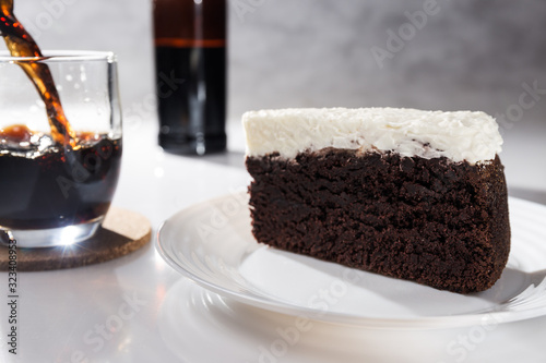 Vászonkép Portion of chocolate cake and black beer on white background with bottle