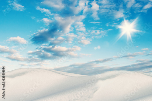 Snow Dunes with Beautiful Clouds on Morning Blue Sky. Bright Empty Winter Background for Graphic Designs.