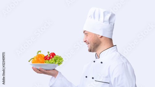Chef Holding Plate With Vegetables Over White Background, Panorama, Side-View