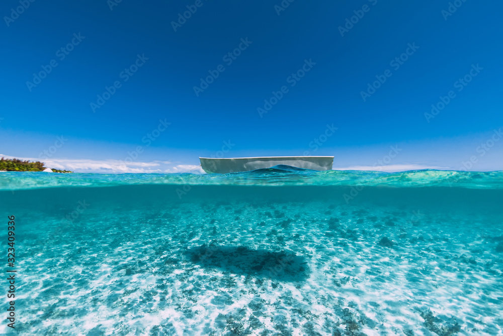 Tropical ocean water with sandy bottom and boat