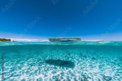 Tropical ocean water with sandy bottom and boat